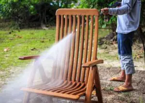 Cleaning outdoor rocking chair as part of how to refinish a wooden rocking chair